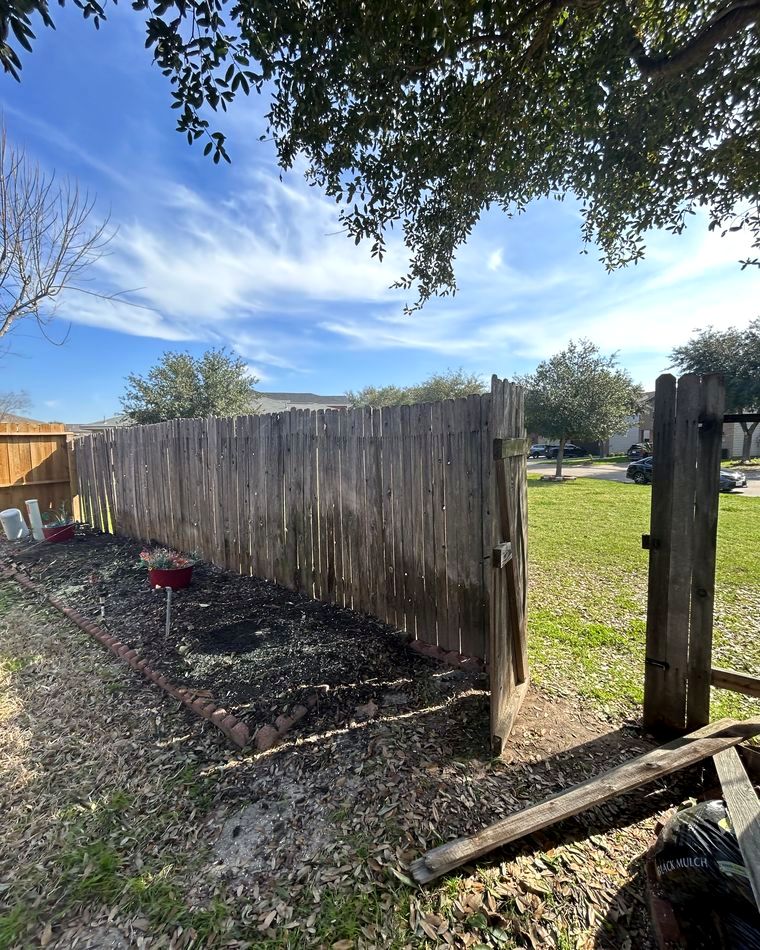 Old grey fence leaning before replacement
