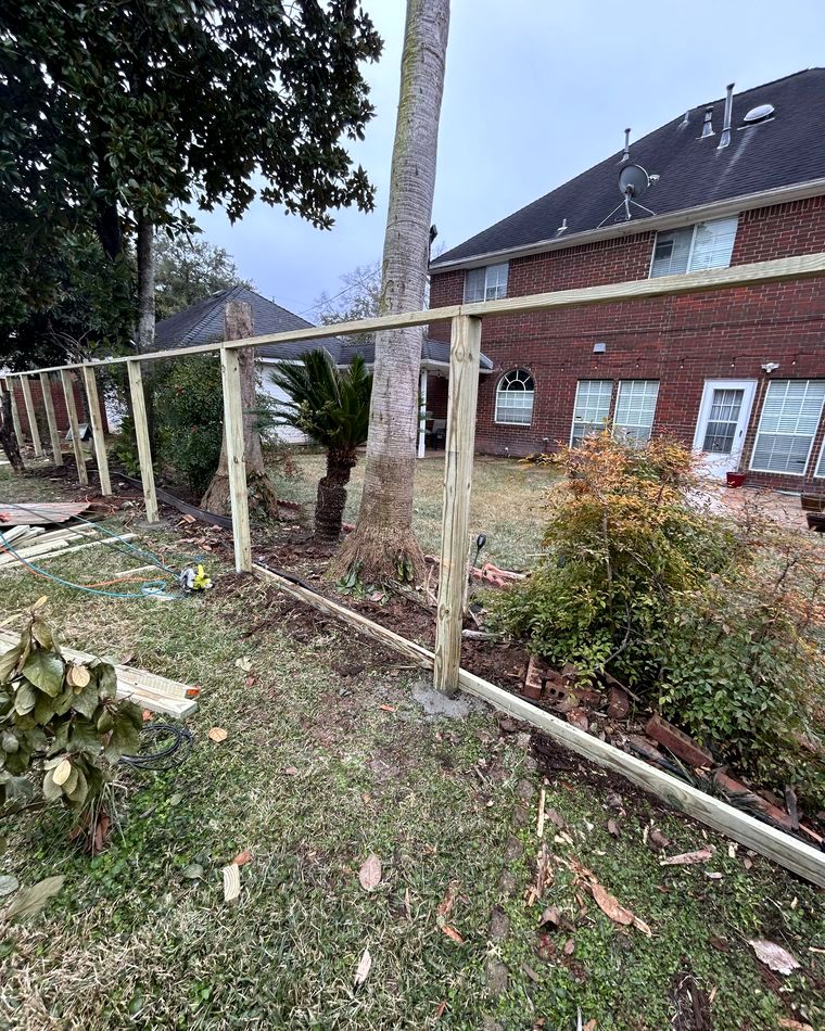 Fence posts set in concrete before pickets